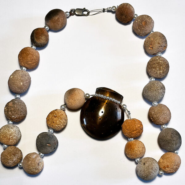 Ketting met een koperen buideltje hanger en aardewerk kralen